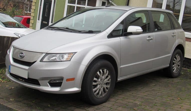 Monospace BYD e6 gris stationné devant une maison, représentant une voiture électrique familiale utilisée au quotidien.