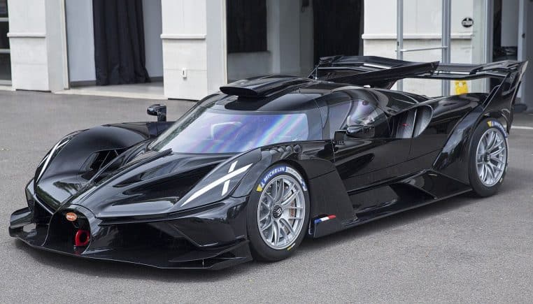 Bugatti Bolide 2025 noire vue de trois-quarts avant, exposée en intérieur à un salon, avec éclairages de stand et sol brillant.