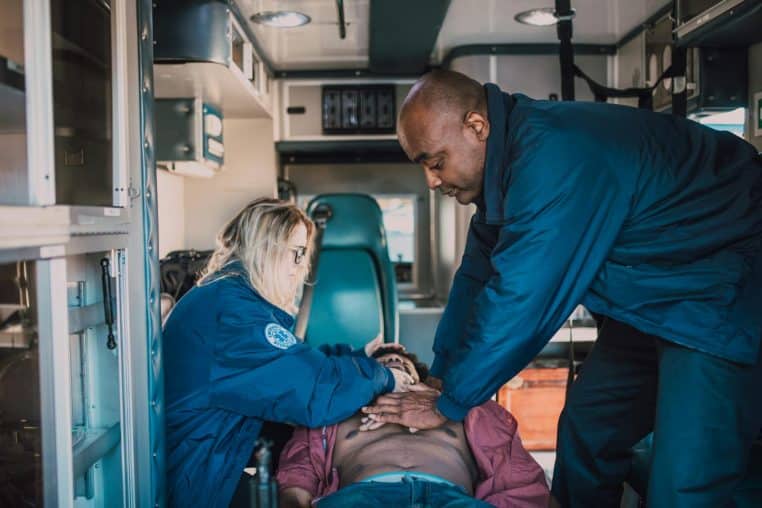 Emergency medical team providing CPR to patient inside an ambulance.