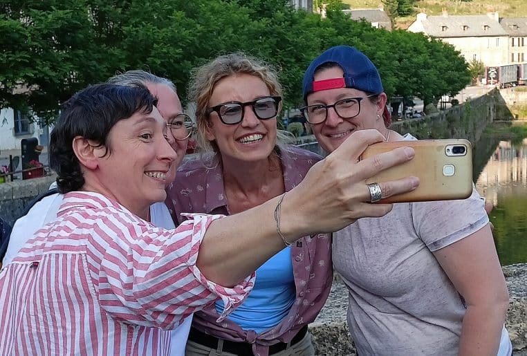 Alexandra Lamy sur un tournage à Estaing en juin 2025, prise de vue horizontale en extérieur, cadrage large.