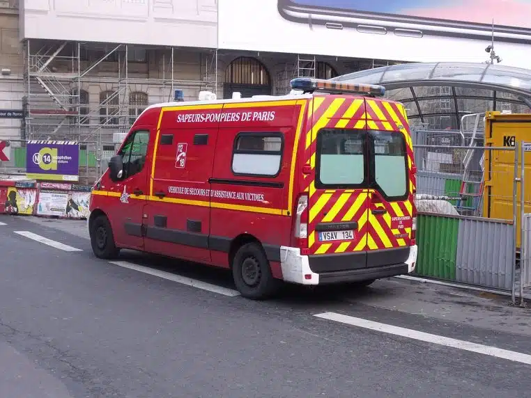 Véhicule de secours VSAV des pompiers de Paris sur le parvis de la gare Saint-Lazare, gyrophares visibles.