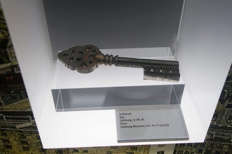 Clé ancienne en métal photographiée en plan horizontal, texture patinée et détails visibles sur la tige