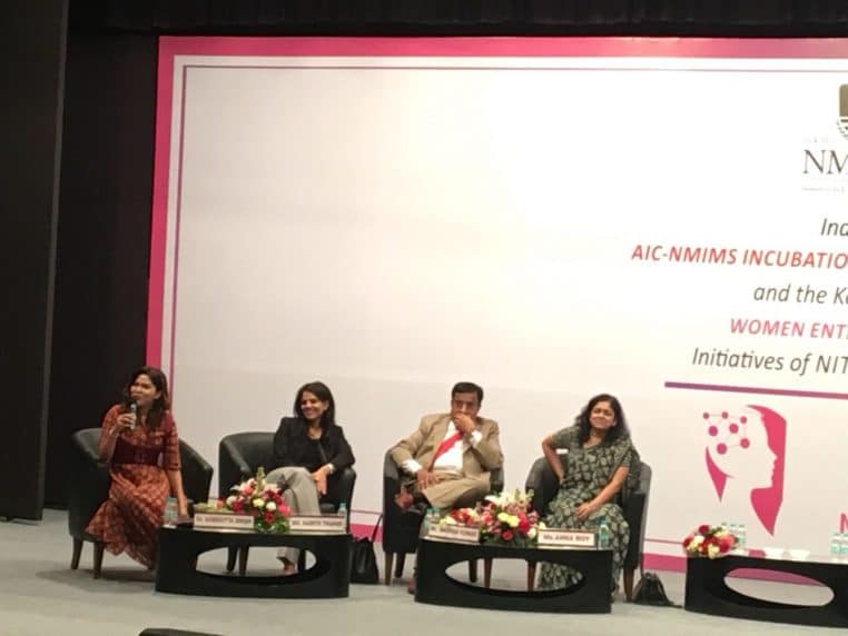 Quatre intervenants, majoritairement des femmes, prennent la parole sur une grande scène lors d’un événement professionnel.