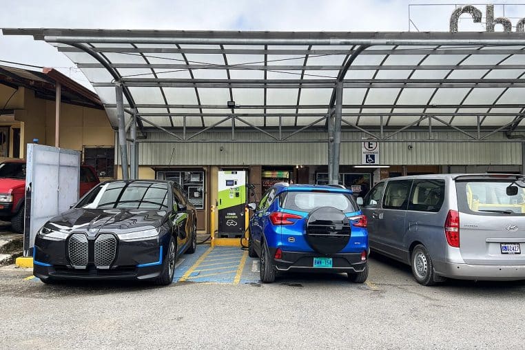 BMW iX et SUV BYD en charge sur une même station, devant un petit restaurant, illustrant l’usage concret des bornes rapides.