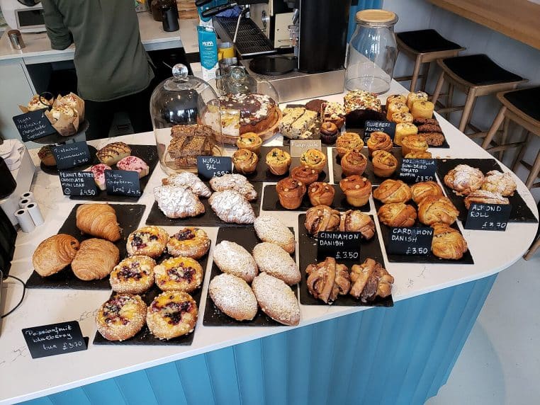 Comptoir de boulangerie garni de gâteaux chocolat et pistache, étiquetés, rappelant un choix de bûches de Noël en vitrine.