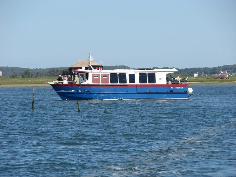 Panorama du bassin d’Arcachon vu depuis Lège-Cap-Ferret, avec plage, eau calme et maisons en bord de rive sous un ciel dégagé.