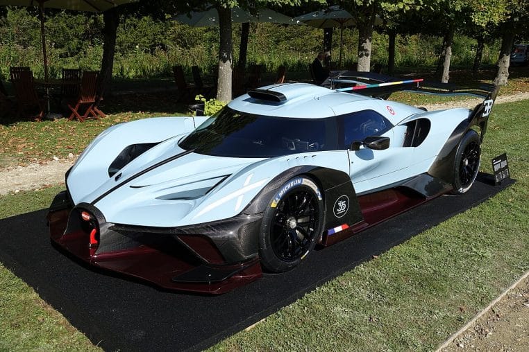 Bugatti Bolide noire et bleue photographiée de trois-quarts avant en extérieur lors du Chantilly Arts & Elegance 2024, posée sur la pelouse.
