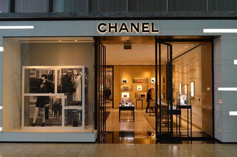Entrée d’une boutique Chanel dans un centre commercial, vitrines lumineuses et logo Chanel en façade.