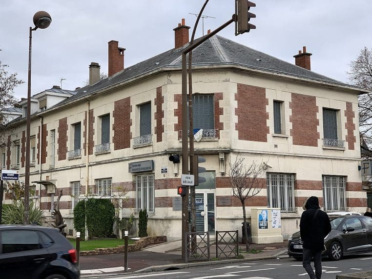 Bâtiment moderne d’un centre des finances publiques de banlieue, photographié en journée avec son entrée principale visible.