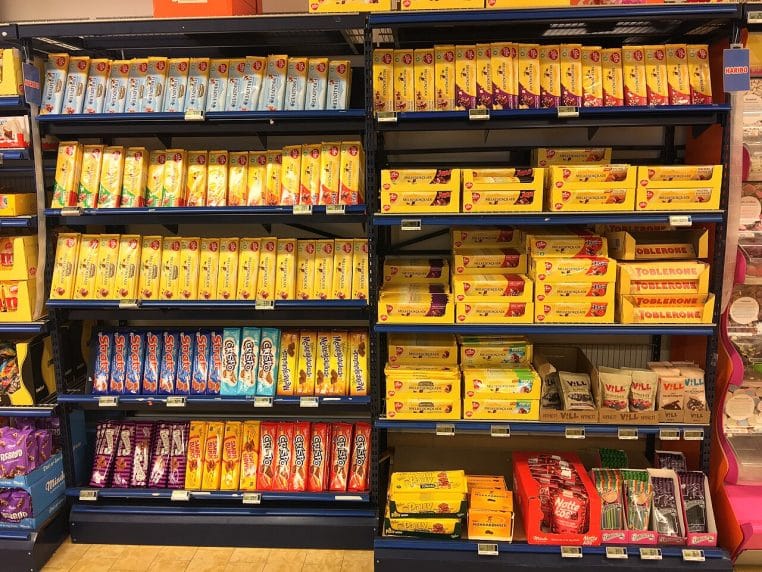 Rayon confiserie en supermarché, tablettes de chocolat en linéaire, emballages colorés bien rangés
