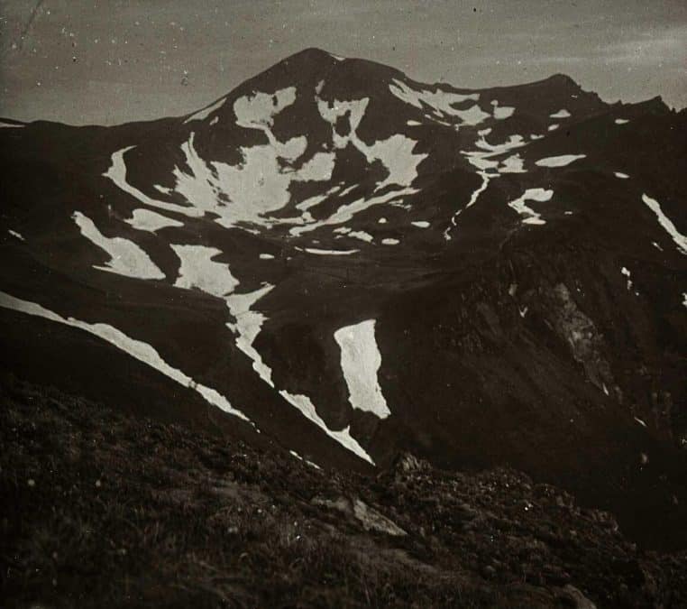 Vue ancienne en noir et blanc du cirque du puy de Sancy enneigé dans le Massif central, avec reliefs marqués et pentes recouvertes de neige.