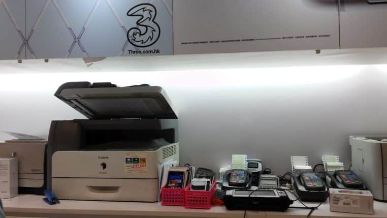 Comptoir de magasin high-tech avec imprimante, terminaux de paiement et accessoires, vue horizontale sur le plan de travail