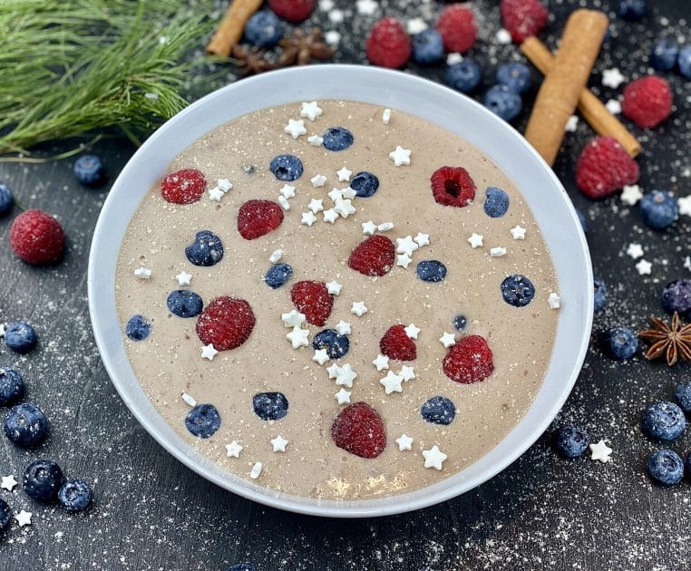 Bol de flocons d’avoine garnis de fruits rouges et de graines, vu de dessus, illustrant un petit-déjeuner riche en fibres et en céréales complètes.