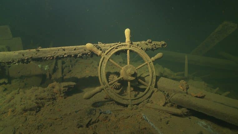 Épave sous-marine en gros plan : roue de gouvernail d’un cargo englouti, illustration du patrimoine archéologique submergé