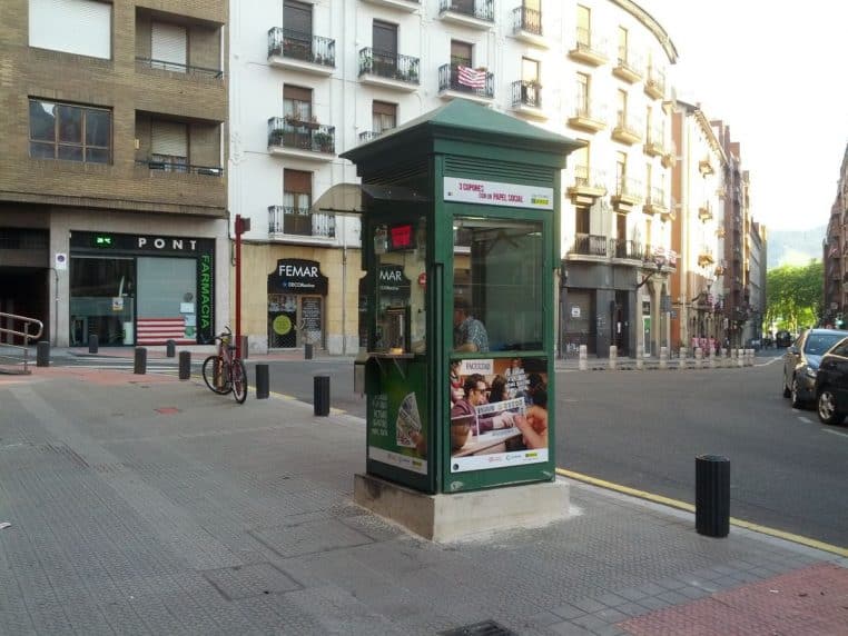 Kiosque vendant des tickets de loterie, étalage visible et ambiance de rue, scène de vente quotidienne.