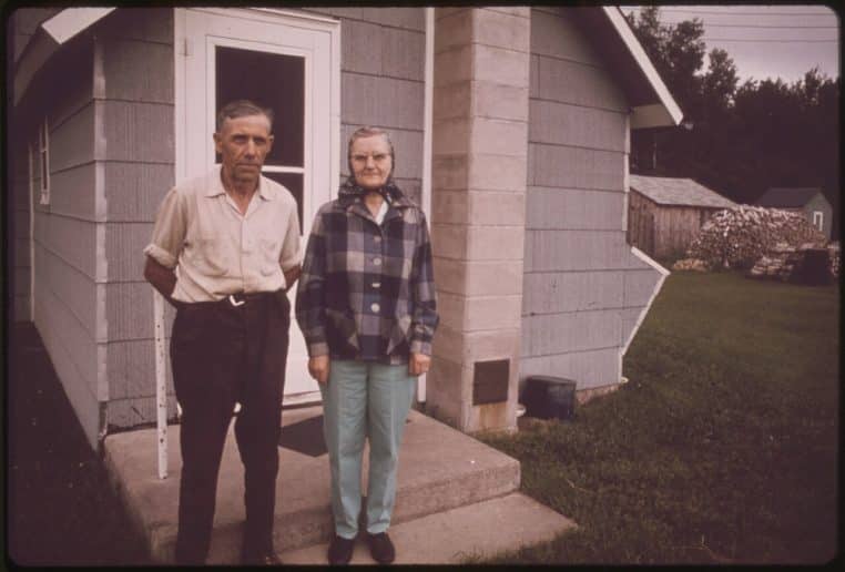 Couple de retraités devant leur maison, image de propriétaires seniors concernés par la taxe foncière et ses exonérations.