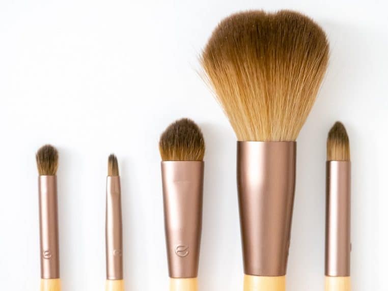 Plusieurs pinceaux de maquillage alignés, gros plan en lumière douce, illustration des gestes beauté au quotidien.