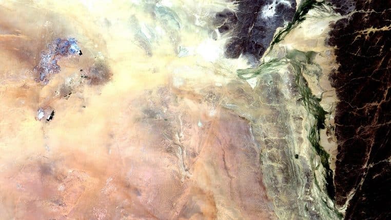 Vue satellite en couleur des mines d’uranium d’Arlit au Niger, au milieu du désert saharien, avec les zones d’extraction contrastant avec les dunes
