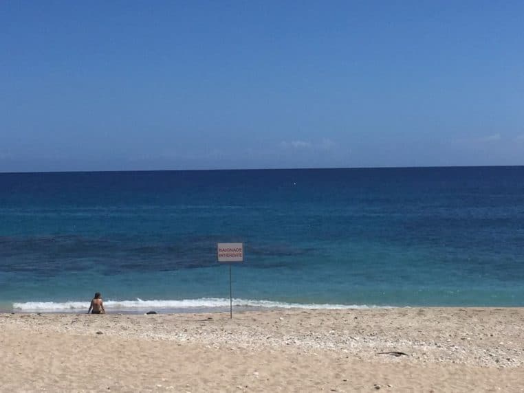 « Ruban et panneau « baignade interdite » sur la plage de Boucan-Canot à La Réunion, face à la mer au calme relatif. »