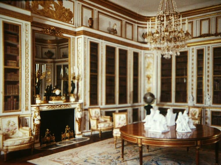 Bibliothèque de Louis XVI à Versailles, boiseries raffinées et rayonnages, décor patrimonial lumineux.