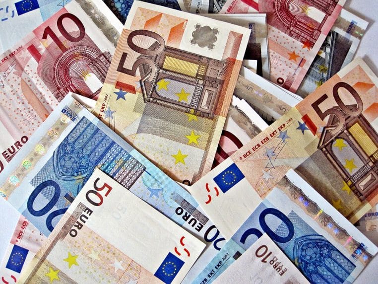 Pile de billets d’euros de plusieurs coupures entassés les uns sur les autres, suggérant des sommes importantes susceptibles d’être transmises en donation.