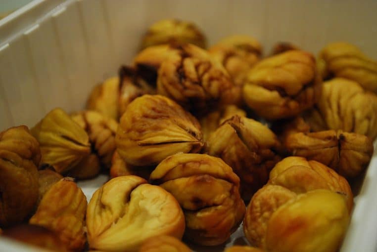 Assiette de châtaignes rôties et déjà épluchées, posée sur une table, illustrant une portion de fruit d’automne bénéfique pour le cholestérol.