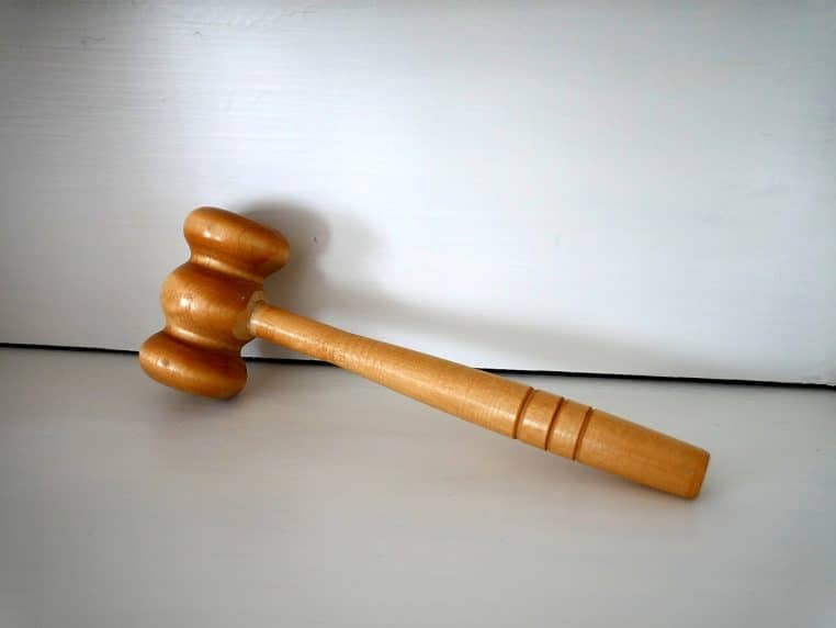 Marteau de juge en bois clair posé sur une surface blanche, illustrant une décision de justice modifiant les règles des congés payés.