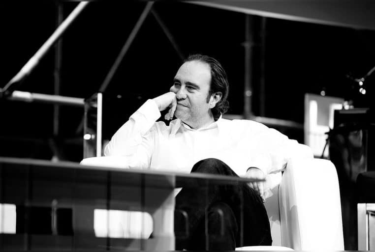 Xavier Niel en costume sombre, photographié de profil sur scène lors de la conférence Le Web 2011, devant un fond bleu légèrement flou.