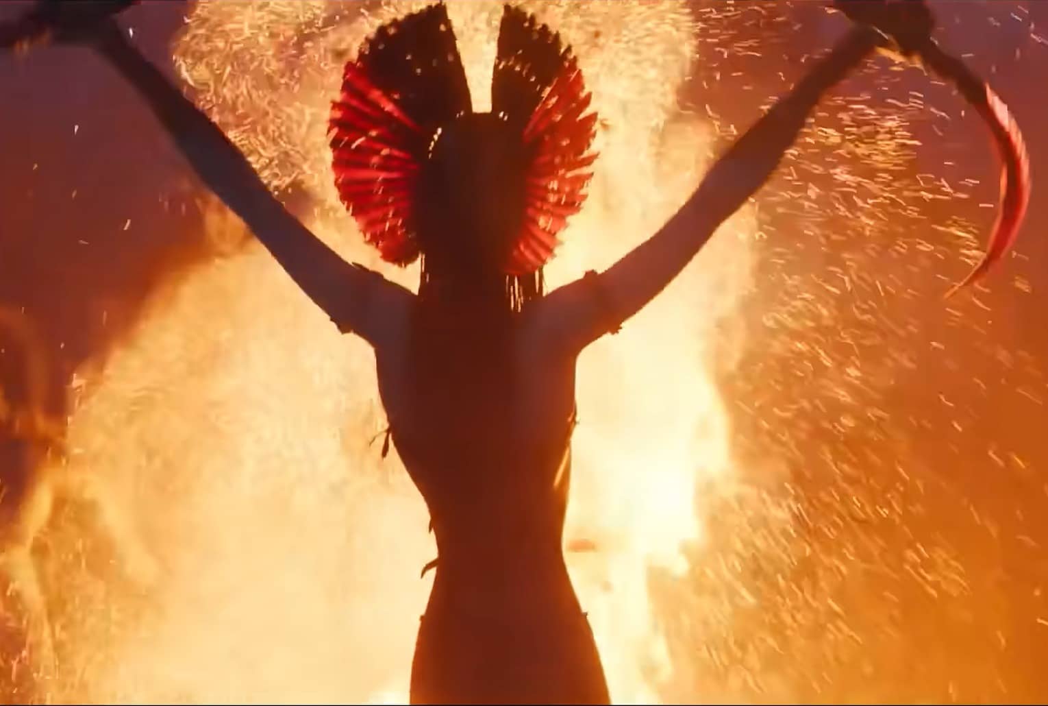 Silhouette d’une Na’vi brandissant des armes devant un brasier, scène rituelle et guerrière dans Avatar 3, ambiance feu et cendres.