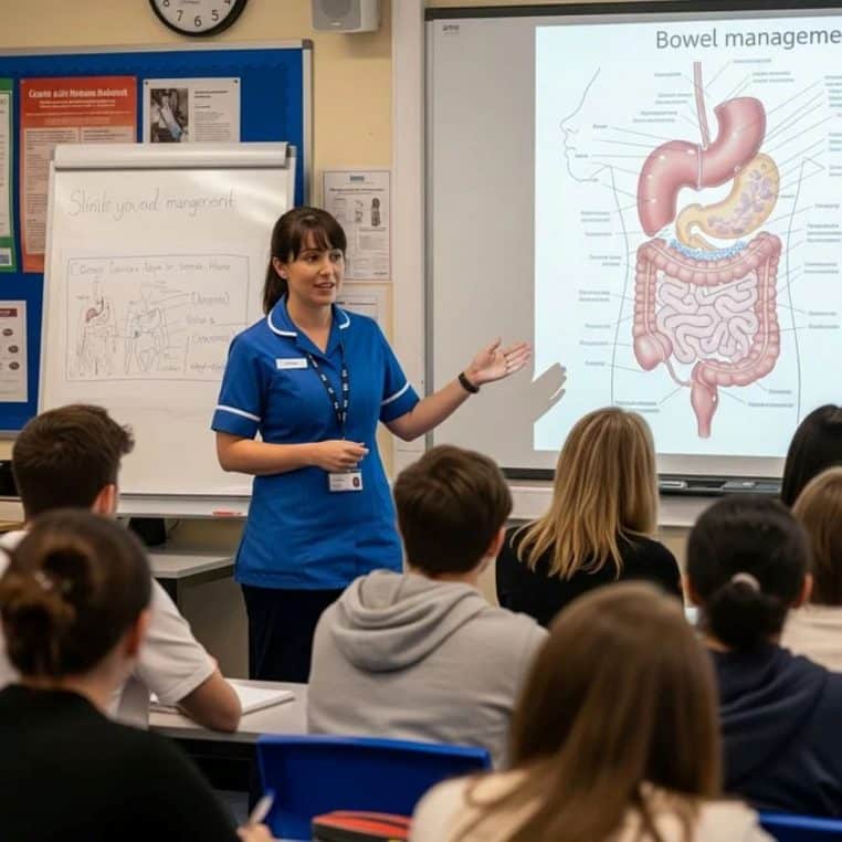 Infirmière en blouse bleue expliquant l’anatomie digestive devant des étudiants, avec un grand schéma détaillé de l’intestin projeté au tableau.