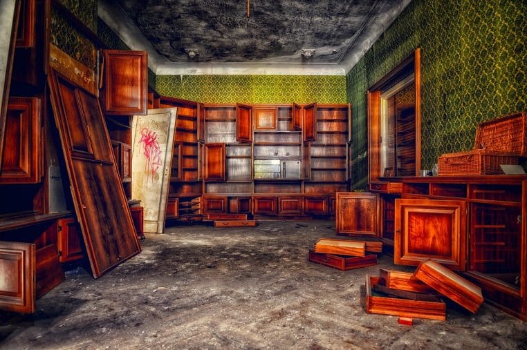 Salon encombré de cartons, de vêtements et d'objets entassés au sol, illustrant le bazar qui cache un vrai pouvoir d'achat.