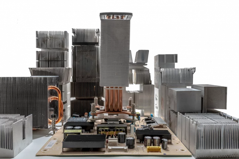 Carte électronique dressée comme une ville de composants et de radiateurs métalliques, évoquant une métropole futuriste construite en déchets informatiques