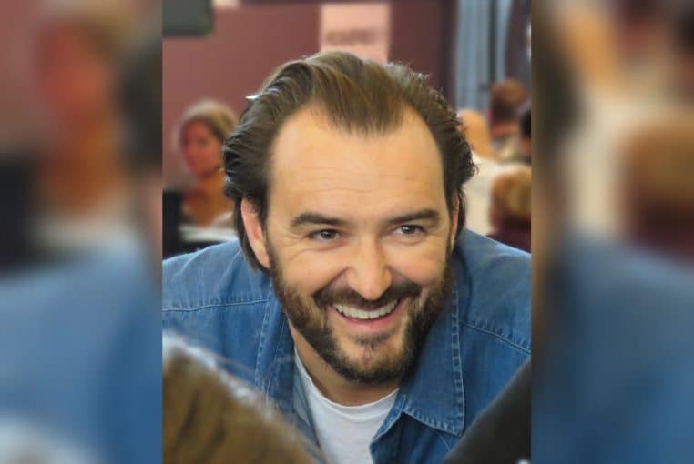 Cyril Lignac souriant au Salon du Chocolat 2017 à Paris, en séance de dédicaces, plan rapproché.