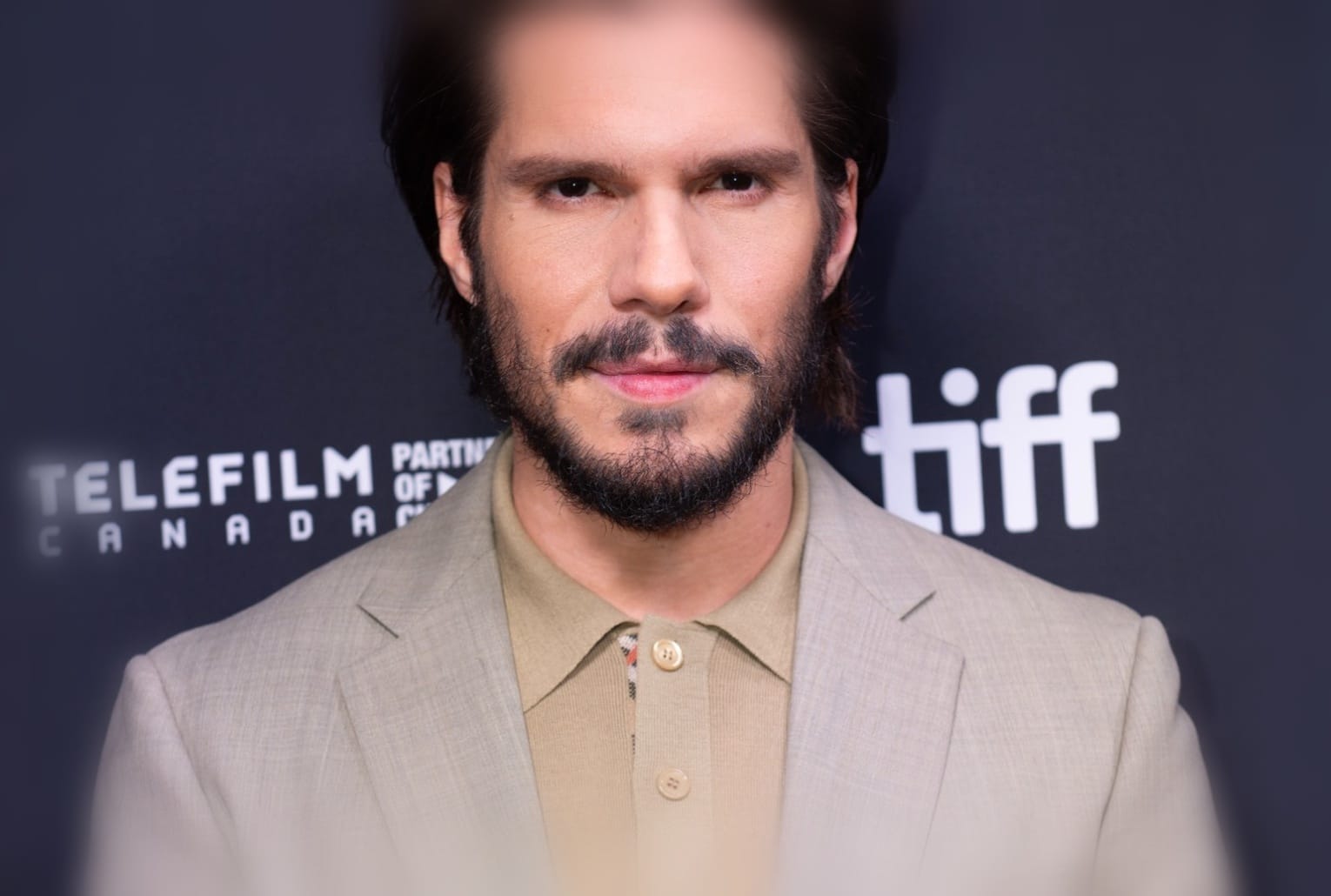 François Civil en costume beige pose devant le photocall du Festival international du film de Toronto 2025, regard tourné vers l’objectif.