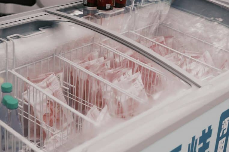 Frozen packaged meat in a supermarket freezer.