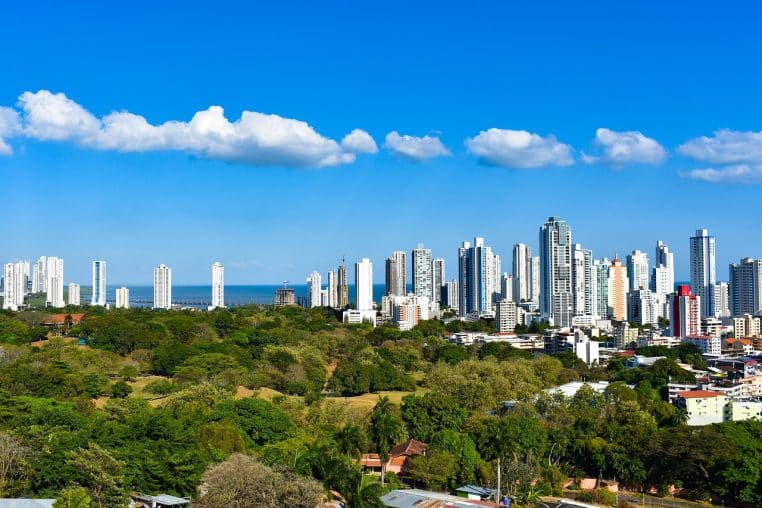 Vue panoramique de Panama City avec gratte-ciel modernes, bande côtière et océan bleu sous un ciel dégagé et quelques nuages