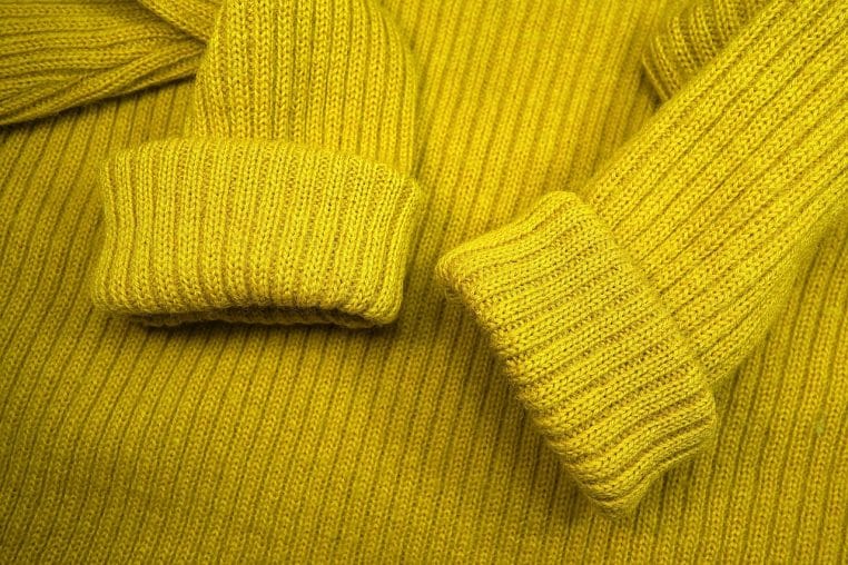 Gros plan sur un pull en maille, pour illustrer les vêtements chauds et l’idée d’une couche isolante en hiver.