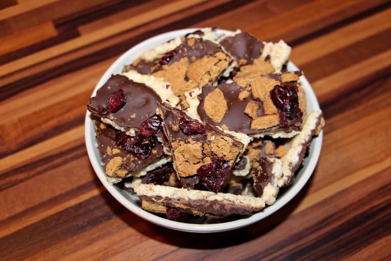 Assortiment de bonbons au chocolat vus de près sur une assiette, avec différentes formes et textures rappelant les boîtes de fêtes de Noël.