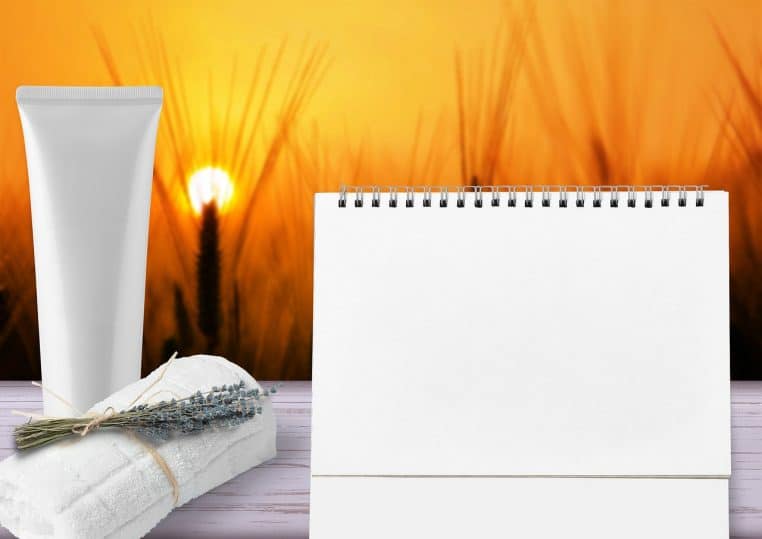 Serviette, produits de soin et calendrier disposés sur une table, évoquant une routine de soins hydratants organisée au quotidien.