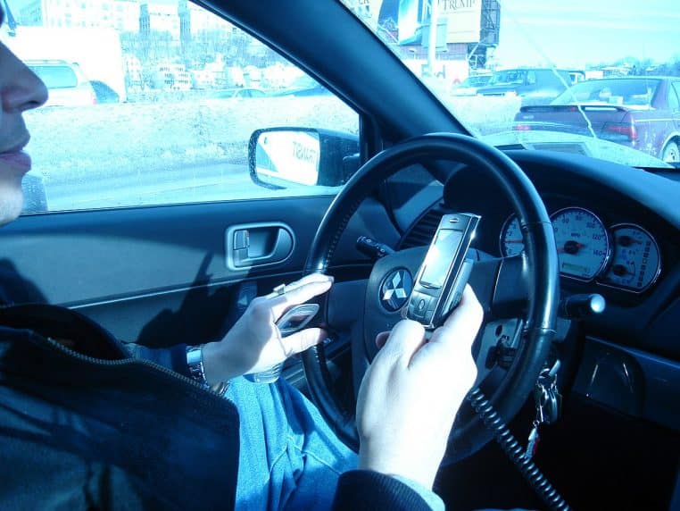 Conducteur tenant un téléphone portable au volant dans un embouteillage