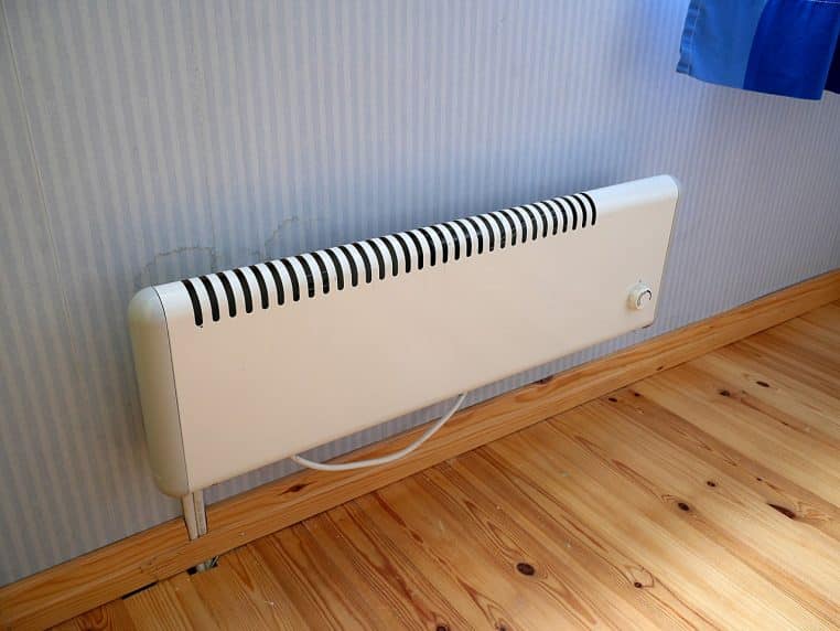 Radiateur électrique blanc fixé au mur, type convecteur/panneau.