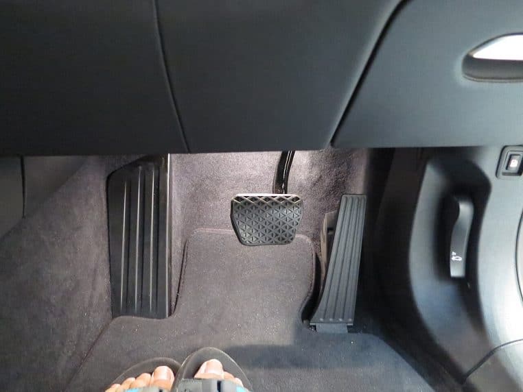 Pédalier d’une BMW moderne : accélérateur et frein dans le repose-pied, aperçu du plancher côté conducteur.