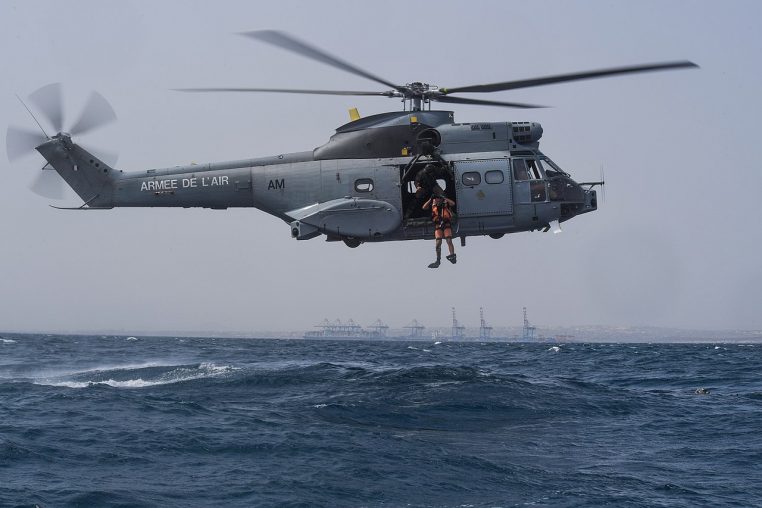 Plongeur de sauvetage sautant depuis un hélicoptère lors d’un entraînement en mer.