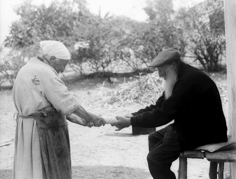 Photo ancienne d’un couple âgé dans une cour, scène de vie quotidienne utile pour parler de droits et démarches