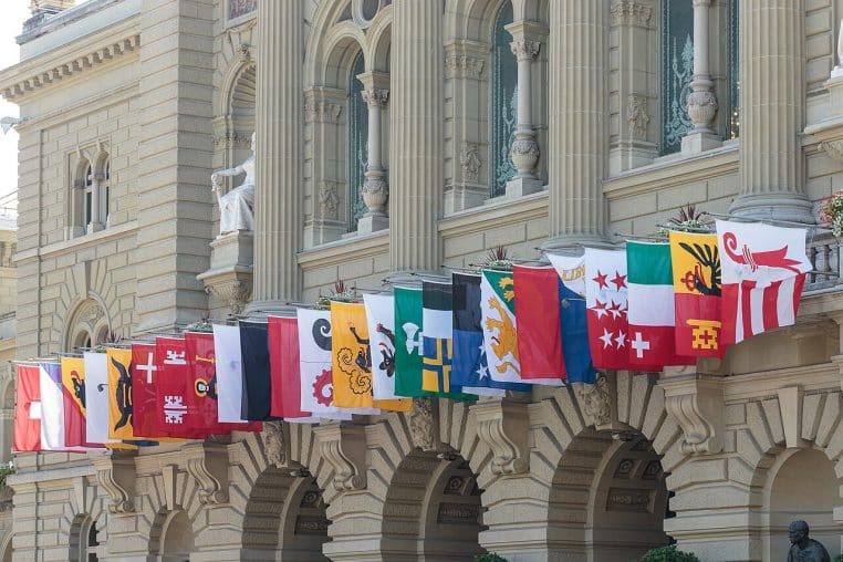 Rangée de drapeaux cantonaux accrochés à la façade du Palais fédéral à Berne lors de la fête nationale