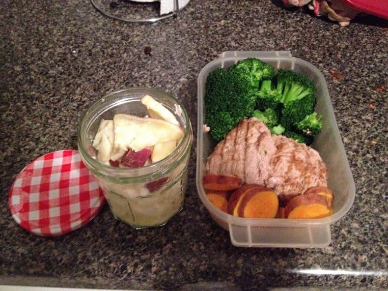 Boîte repas type meal prep avec brocoli, viande et patate douce, à côté d’un bocal sur un plan de travail.