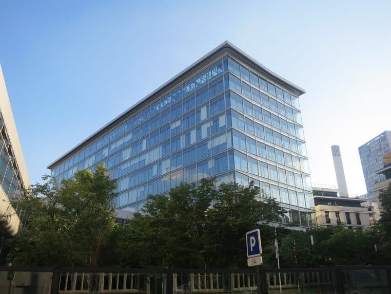 Façade vitrée d’une Caisse d’allocations familiales à Paris, bâtiment moderne en plein jour, vue depuis la rue.
