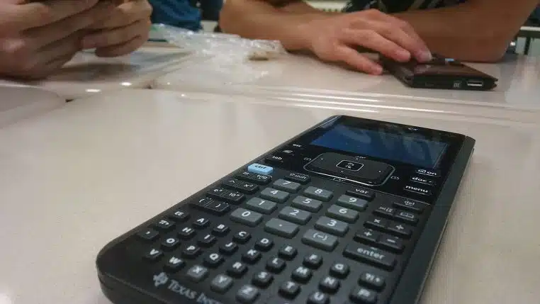 ne calculatrice posée sur une table, vue en perspective, ambiance bureau et préparation de calculs