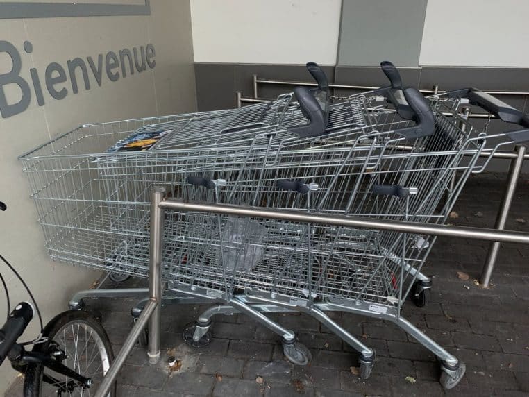 Rangée de chariots de supermarché devant un Lidl, cadrage large et net, ambiance urbaine en extérieur.