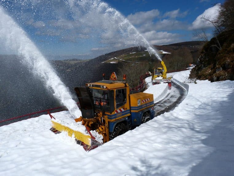 Déneigement d’une route de crête dans les Vosges : engin de service en action repoussant la neige sur une route blanche.